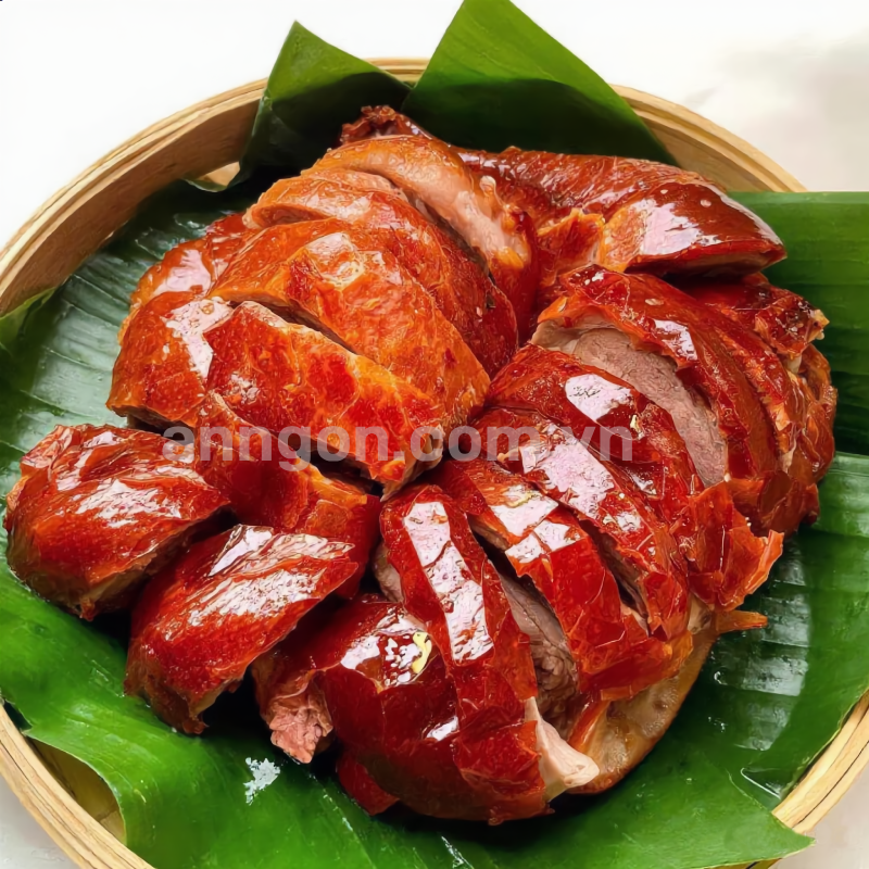 Vịt quay da giòn nửa con với lớp da vàng óng giòn rụm, thịt mềm ngọt, ăn kèm rau răm, dưa leo và nước chấm đặc biệt